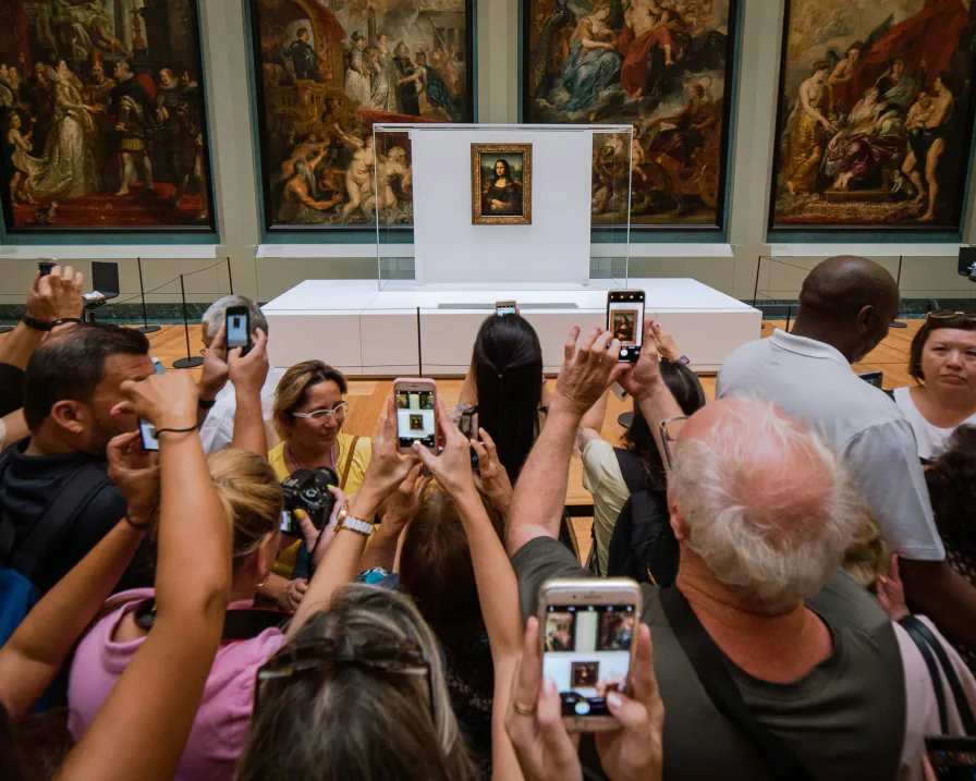 Visitatori fotografano la Gioconda esposta al Louvre — foto di Mika Baumeister